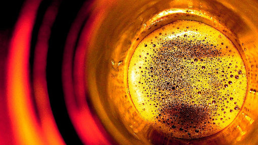 Un bicchiere di Birra artigianale visto dall'alto con colori caldi